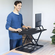 Black | 28-inch-desktop | Lifestyle image of a man using the X-Elite Pro 28 inch Desk Converter in an office environment.