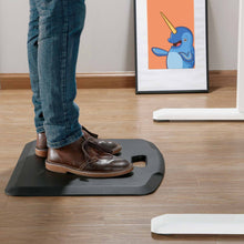 Black | 22-inch-mat | Lifestyle image of the Stand Steady standing mat with handle in a home office setting, small.