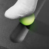 Close-up image of a person rolling their foot on the standing mat's massage ball.