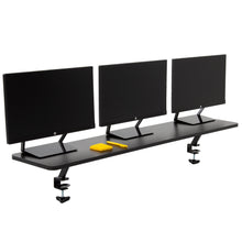 Black | Clamp-on 55" desk shelf float with three screens on it.