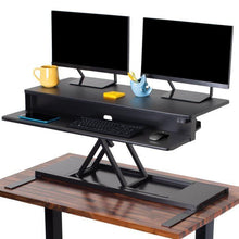 black | 40-inch-desktop | Black 40" electric standing desk converter at tallest setting with two monitors displayed.