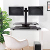 black | two-monitor-arms | Lifestyle image of the 2 monitor Techtonic standing desk converter in an office setting.
