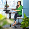 Lifestyle image of the Tranzendesk sit to stand desk by Stand Steady in a home office setting.