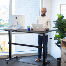 white | white-shelf | Lifestyle image of the Tranzendesk standing desk in an office setting with two monitors on it.