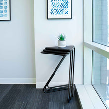 Black | Lifestyle image of the black Vertex end tables stacked together in the corner for easy storage.